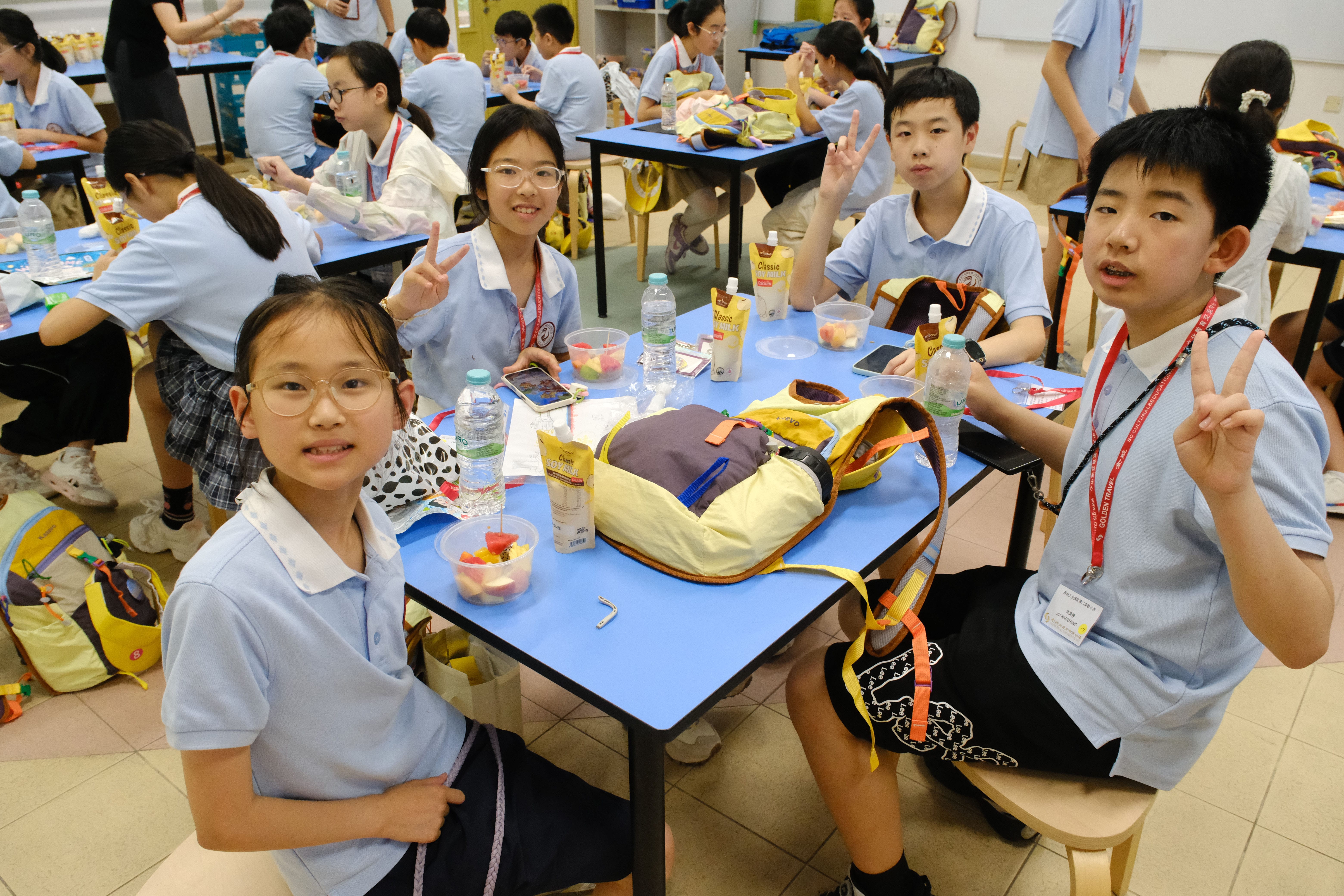 Students enjoying fruit cups and soya milk during snack time. 